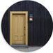Merkloos / Sans marque Dibond Muurcirkel - Houten Gebouw met Gele Deur - 80x80 cm