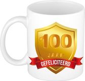 Bellatio Decorations Leeftijd cadeau koffiemok - 100 jaar - Gefeliciteerd - Gouden schild en wimpel - jubileum - verjaardag - beker - 300 ml - wit