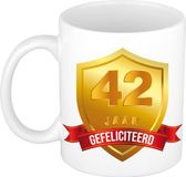 Bellatio Decorations Leeftijd cadeau koffiemok - 42 jaar - Gefeliciteerd - Gouden schild en wimpel - jubileum - verjaardag - beker - 300 ml - wit