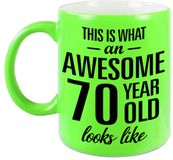Bellatio Decorations Awesome 70 year verjaardag cadeau - koffiemok - beker - neon groen - 330 ml - This is what an awesome 70 year old looks like