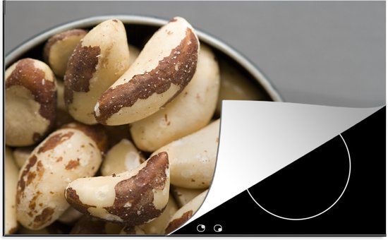 KitchenYeah® Inductie beschermer 77x51 cm - Close up van een kommetje met paranoten - Inductie beschermer voor kookplaat