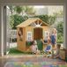 Maisonnette de jeu en bois pour jardin, maisonnette enfants avec porte et fenêtres, 2 jardinières, dimensions 134,5x97x150 cm, teinte brun.